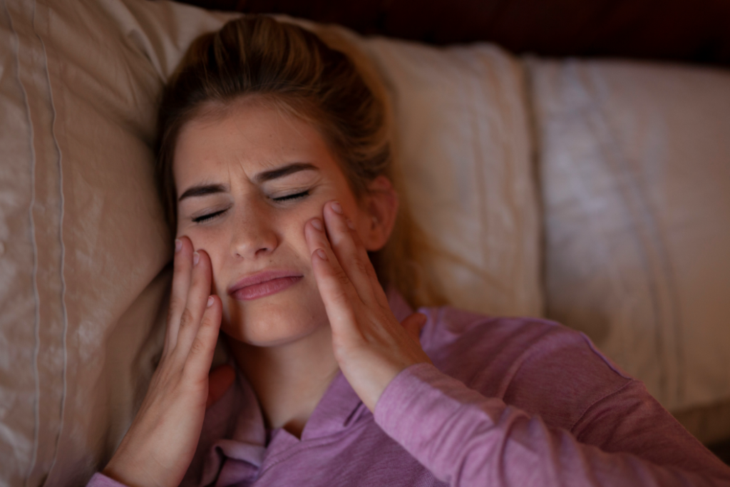 woman holding mouth in pain