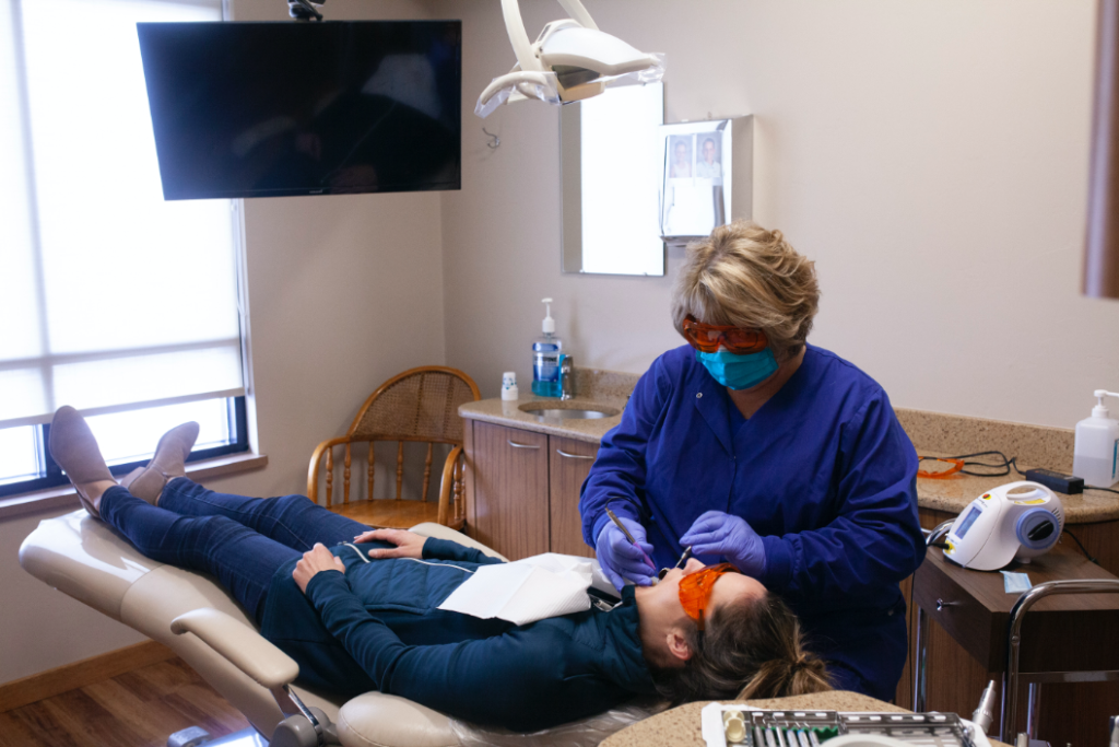 hygienist working on patient watching tv