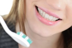 woman with strong teeth enamel smiling with toothbrush