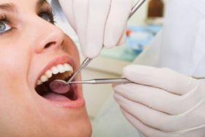 woman getting a dentist exam and teeth cleaning
