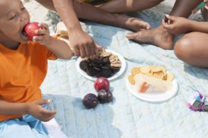 Family having a picnic at the beach with summer treats that can damage teeth