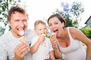 Young parents with their little son eating ice cream with no painful sensitive teeth