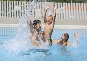 healthy young family swimming in pool